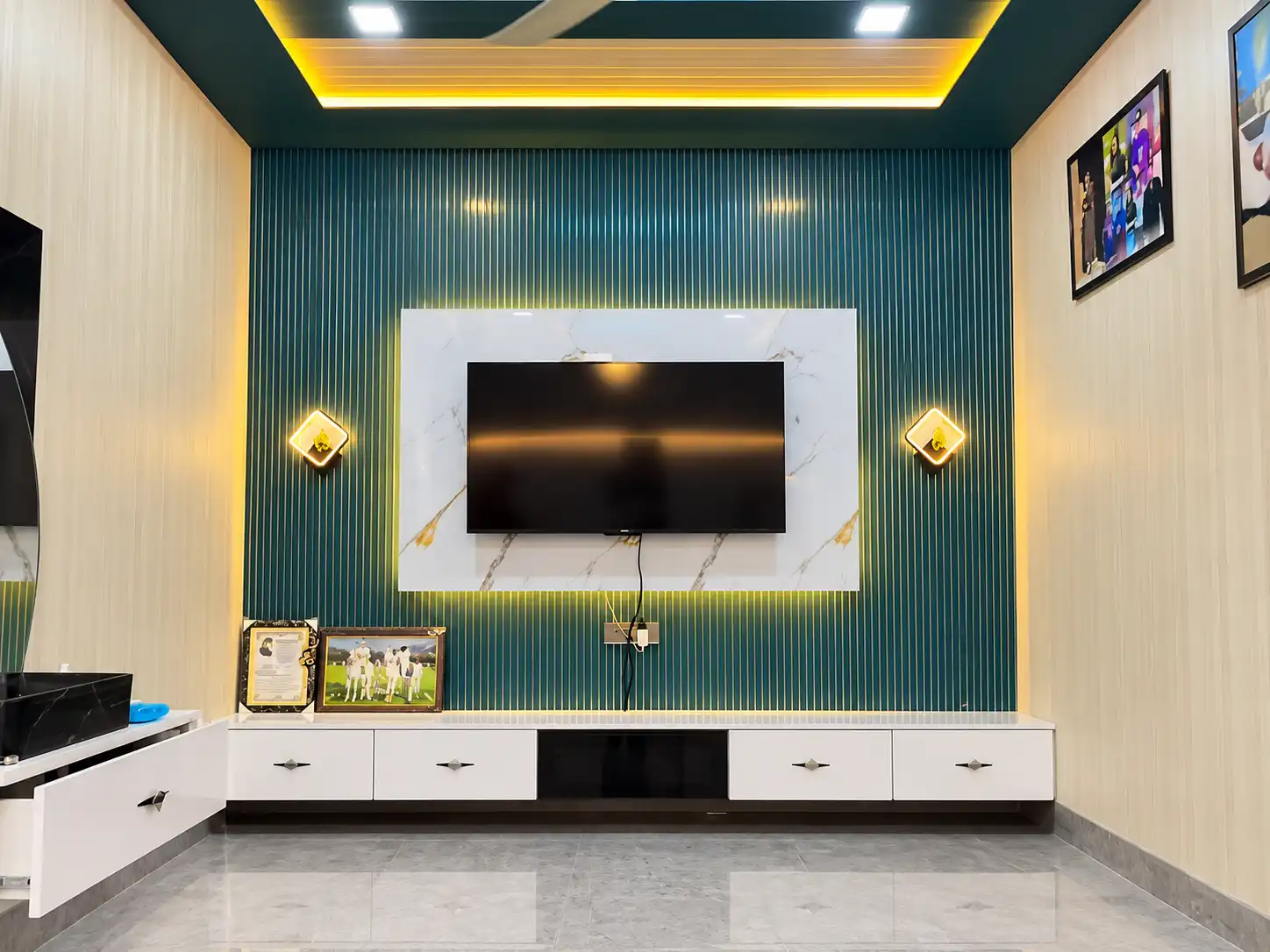 Green fluted TV wall with a white marble-effect frame and warm lighting