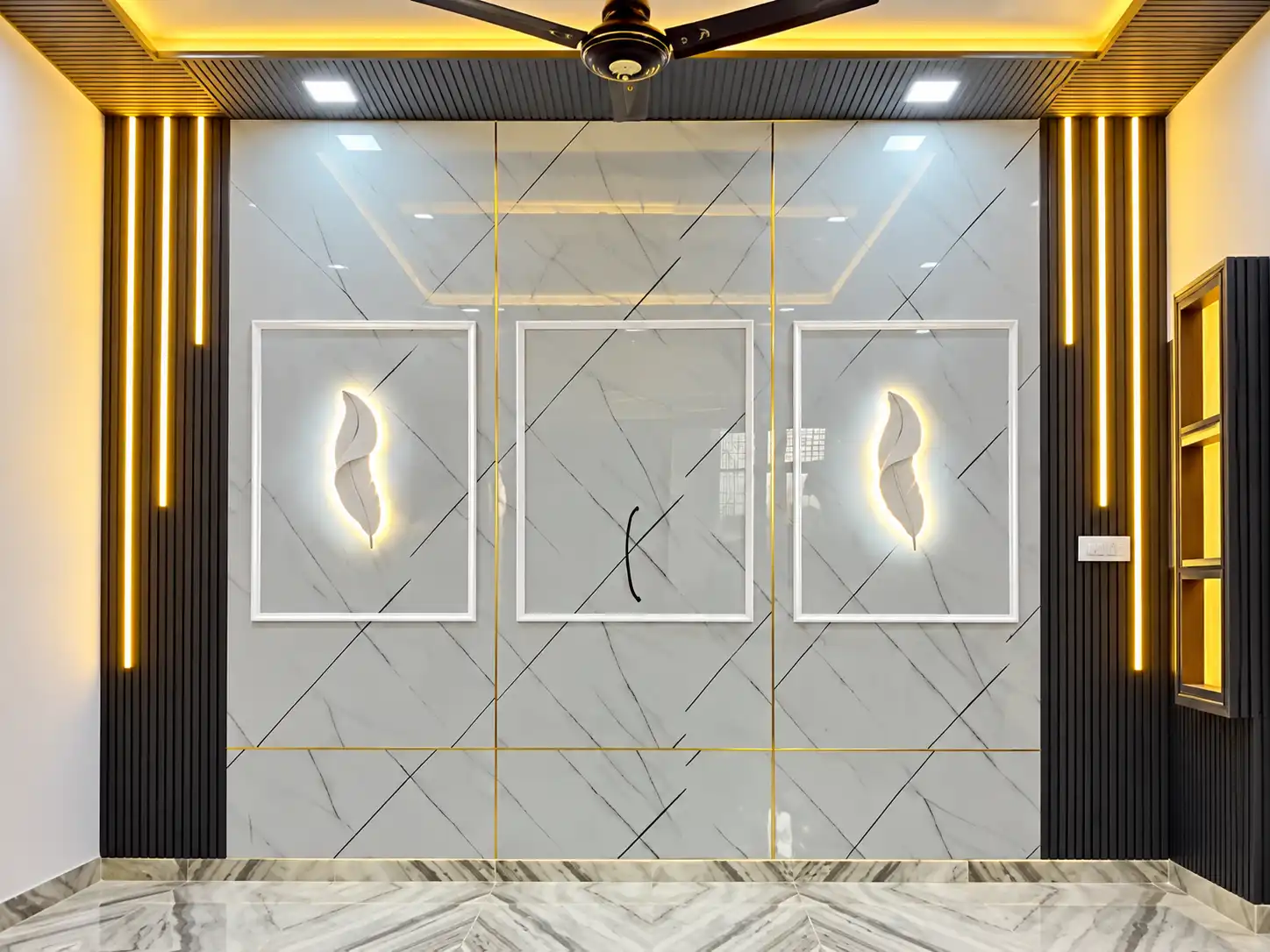 White marble-effect feature wall with black slat side panels and warm lighting